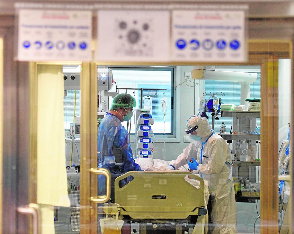 Dos sanitarios atienden a un paciente de Covid en la UCI del Reina Sofía. 