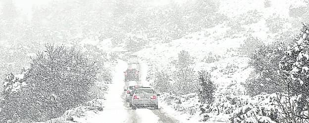 Vehículos circulan por la carretera de Inazares (Moratalla), ayer, en mitad de un paisaje totalmente cubierto por la nieve. 