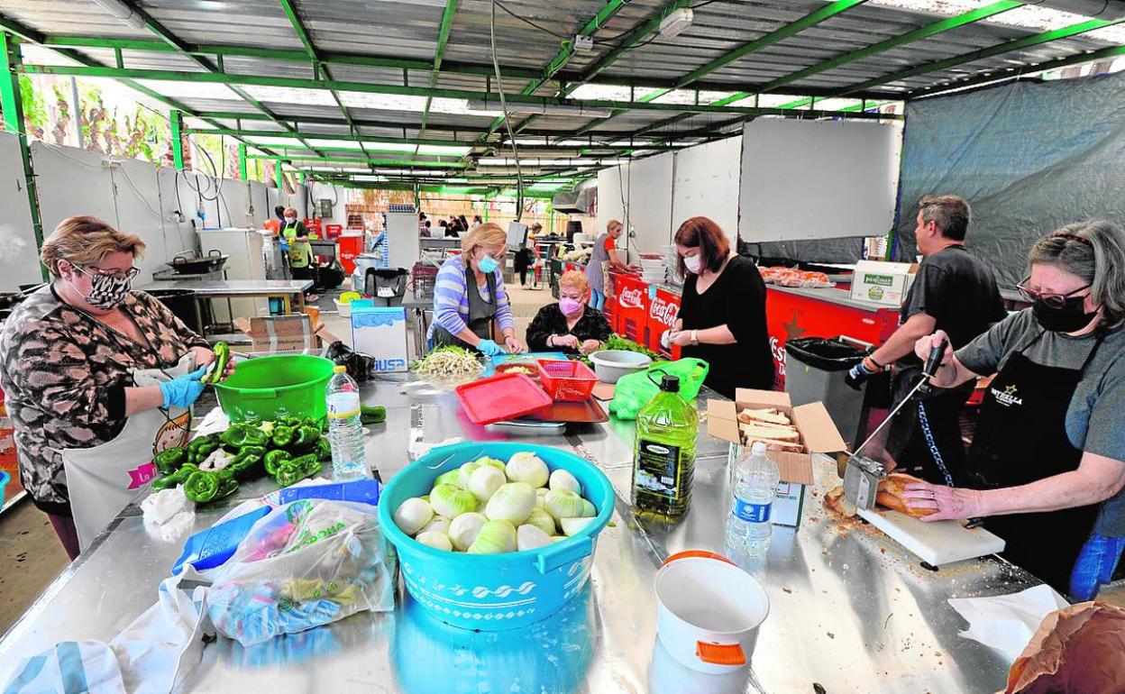 Mujeres se afanaban este sábado en preparar los platos en la sede de la peña El Zarangollo