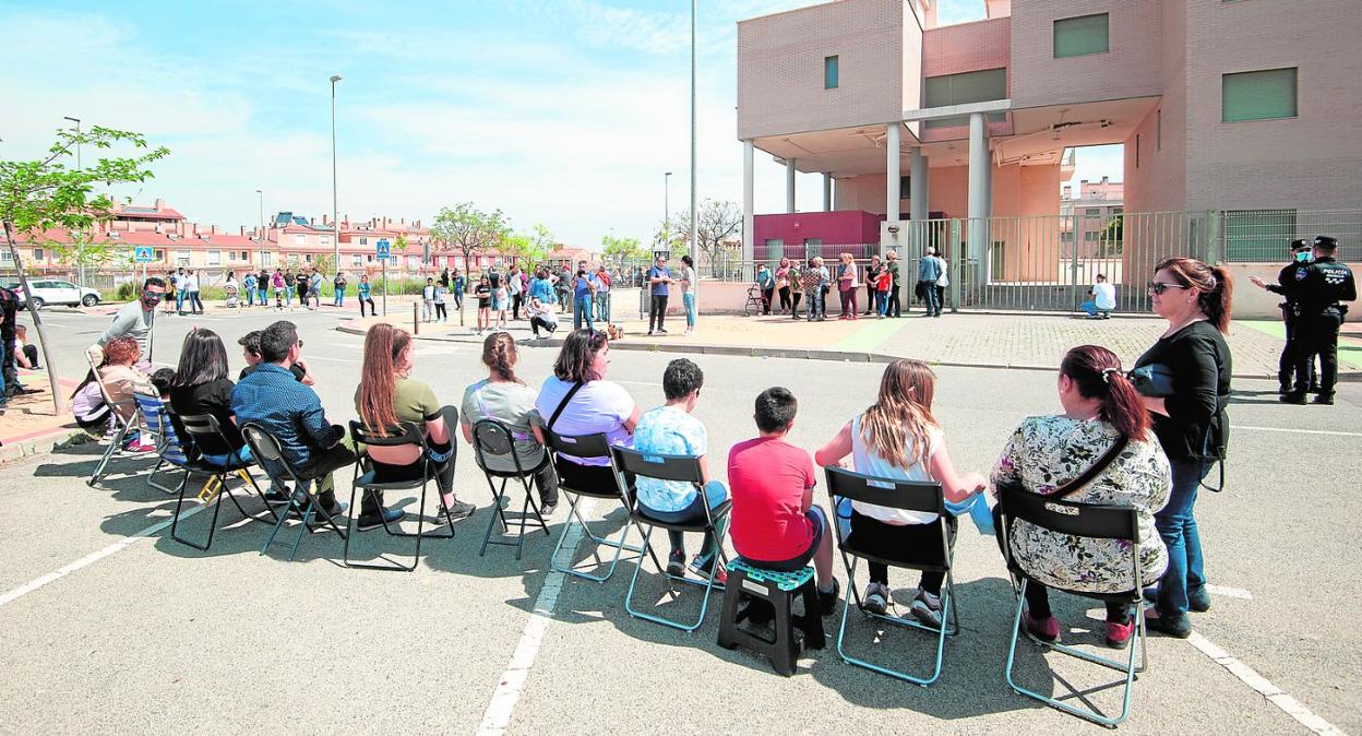 Vecinos vigilan, ayer, sentados frente al edificio abandonado para evitar que las casas sean okupadas, en Sangonera la Verde. 