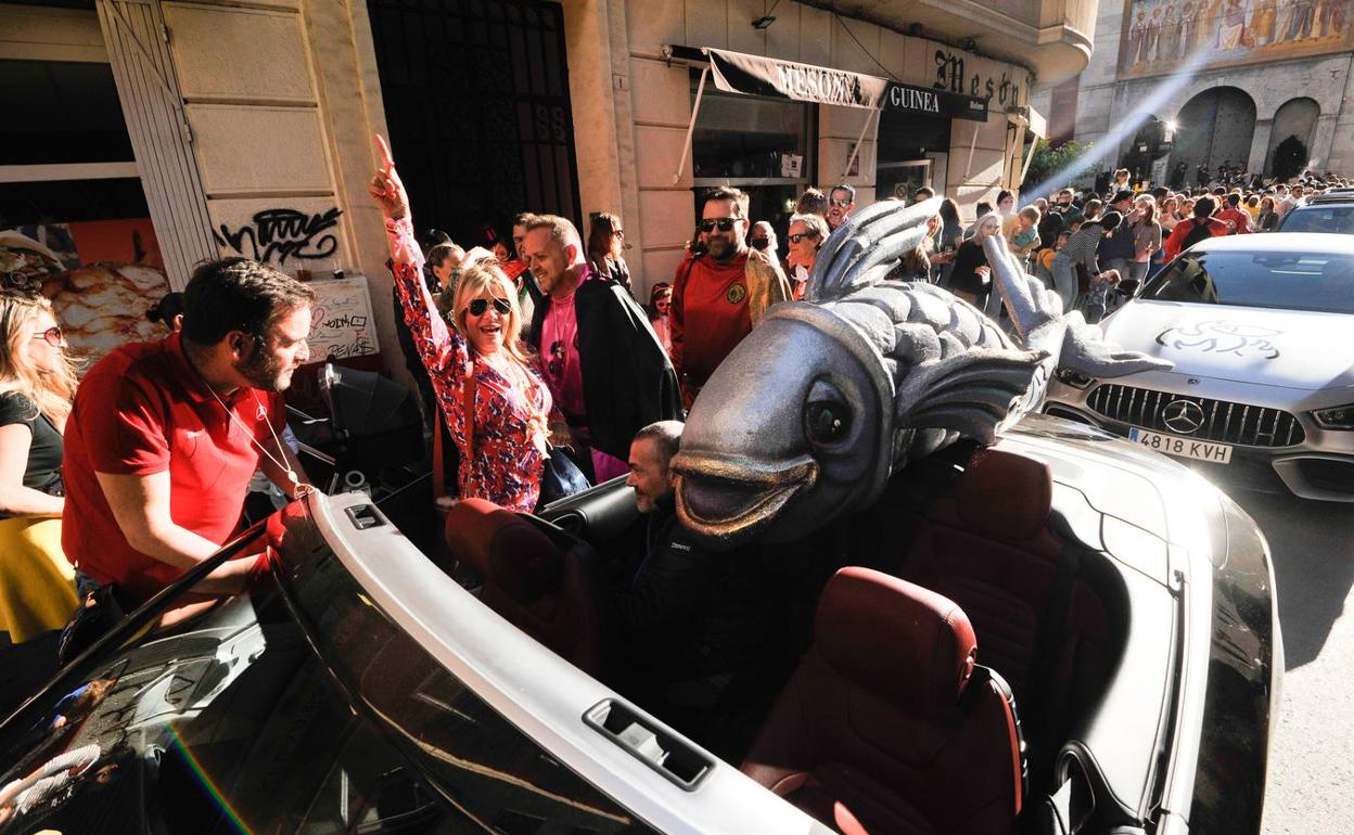 Llegada de la sardina al barrio de San Antolín, en un coche descapotable, con la parroquia al fondo. 