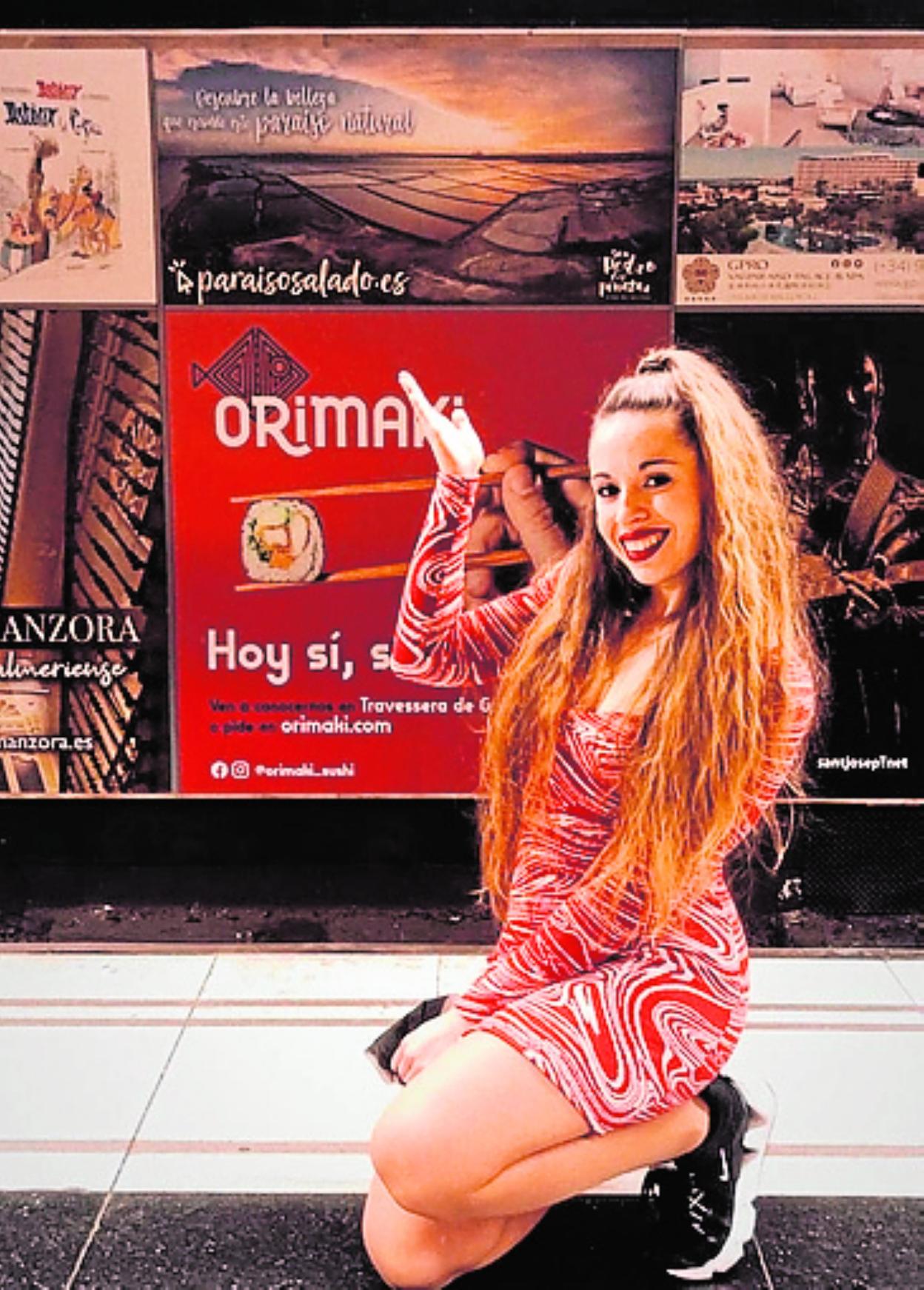 Una joven señala el cartel. 