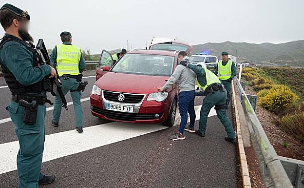 Un agente de la Usecic registra a un conductor detenido tras detectar que ha modificado los números de la matrícula de su coche. 
