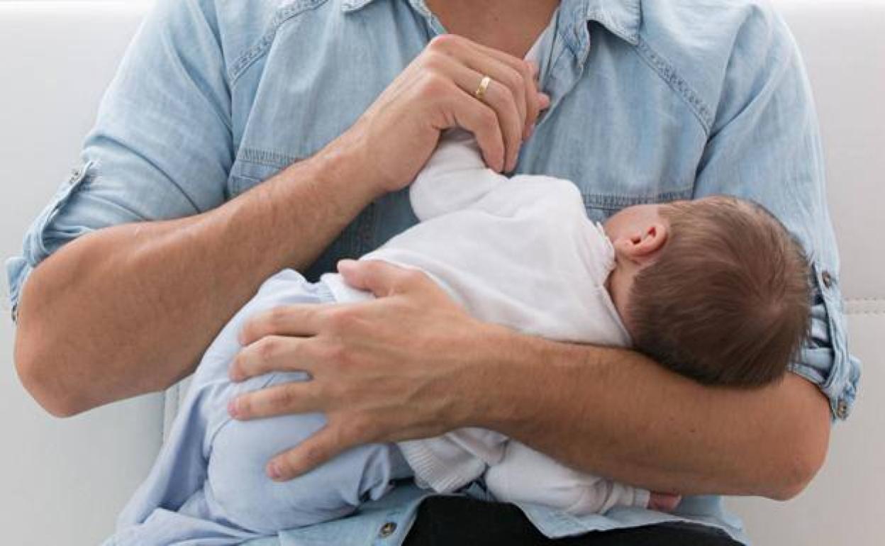 Un padre coge a su bebé en brazos.