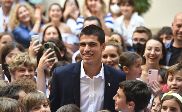 Carlos Alcaraz rodeado de jóvenes tenistas este martes en el Palacio de San Esteban.