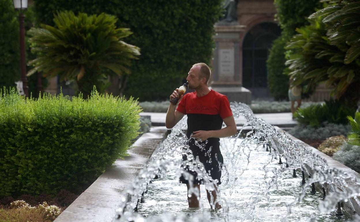 Un hombre refrescandose en una fuente durante la ola de calor del pasado mes de julio. 