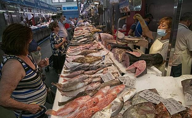 Clientes compran pescado en un puesto del mercado de Santa Florentina, en Cartagena. 