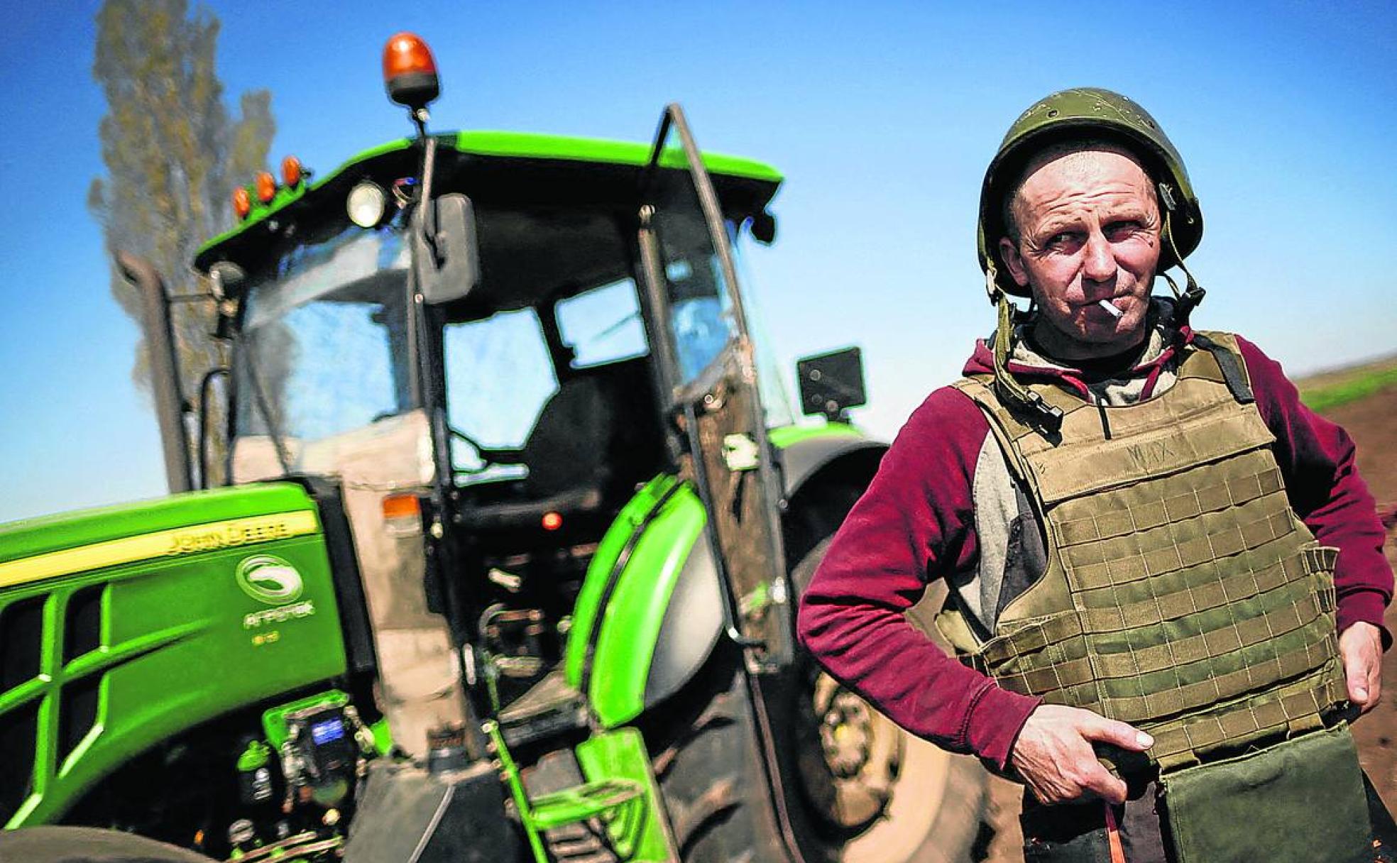 Cereal de sangre. Un granjero ucraniano pertrechado con chaleco antibalas y casco trabaja sus tierras bajo la amenaza de las minas. 