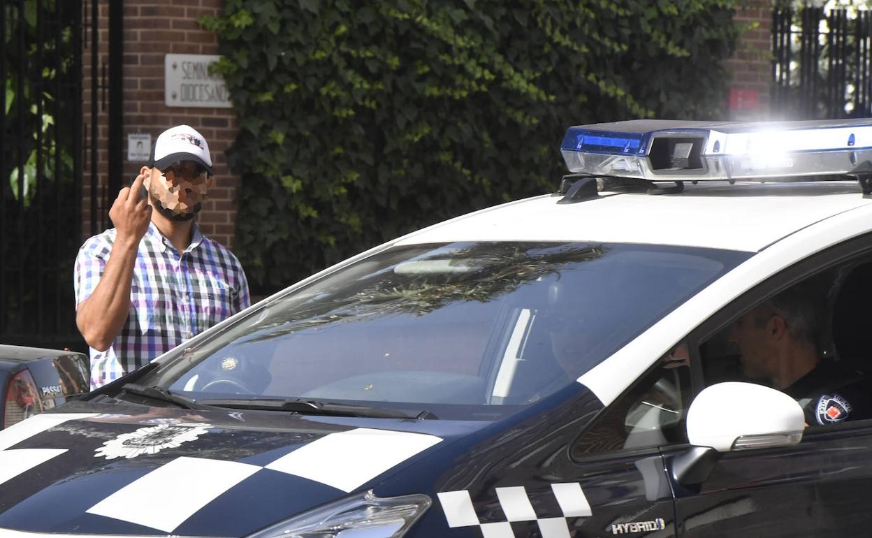 Una patrulla de la Policía Local pasa junto a un 'gorrilla', ayer en la zona de la Jefatura de Tráfico. 