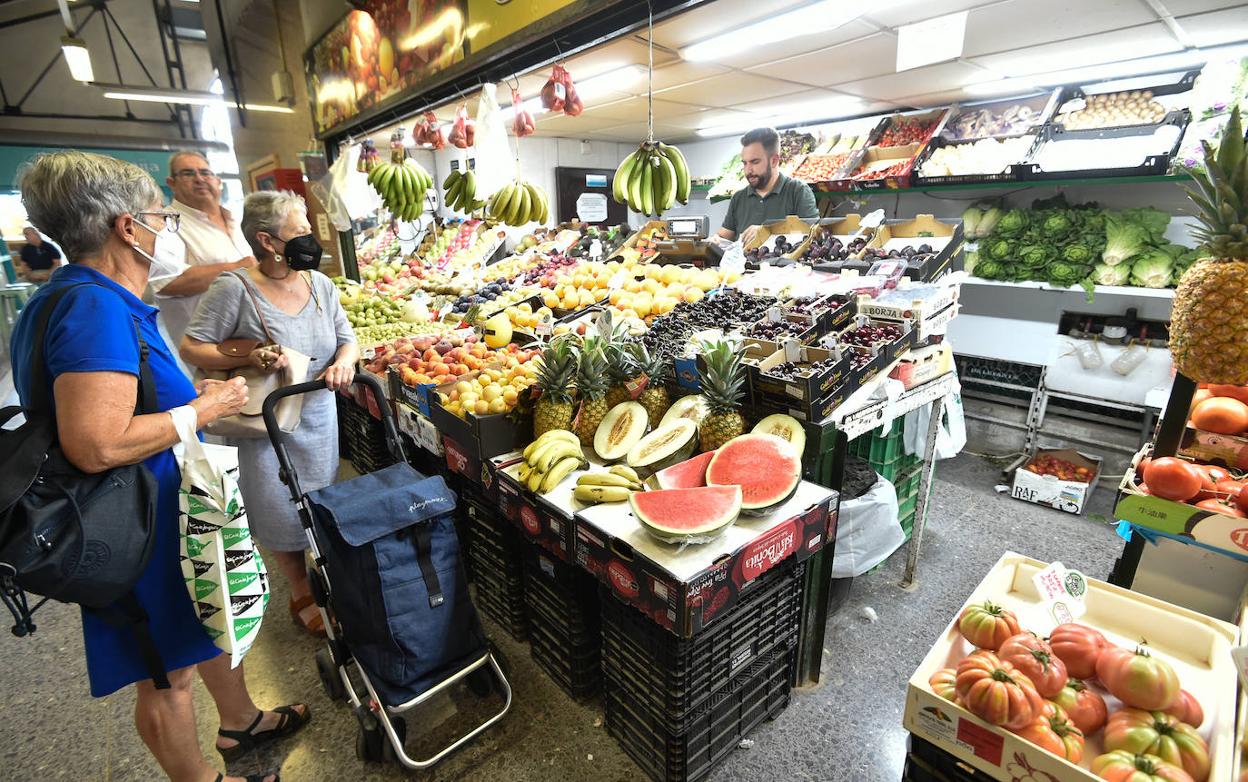 Varios clientes, ayer, en un puesto de fruta y verdura del mercado de Verónicas de Murcia. 