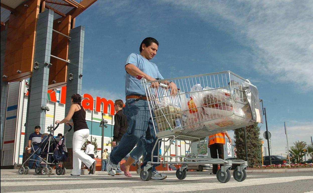 Un hombre sale de un centro comercial de Murcia con su compra.