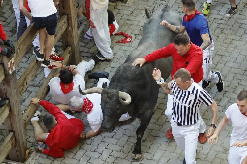 Los mozos corren ante los toros de la ganadería de José Escolar durante el tercer del encierro de San Fermín.