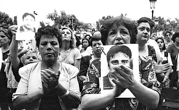 Imagen principal - Arriba: Miradas perdidas, aplausos para Miguel Ángel en Murcia. Abajo: paro en la ciudad de Murcia en recuerdo del edil asesinado y una niña en brazos con una fotografía de Miguel Ángel Blanco. 