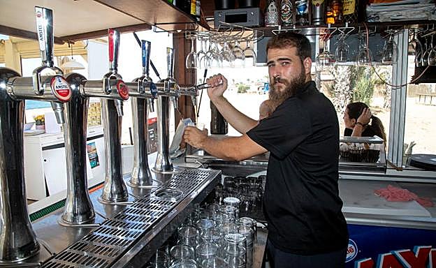 Pablo Valero López sirve una cerveza en el chiringuito de Nares, en Mazarrón. 