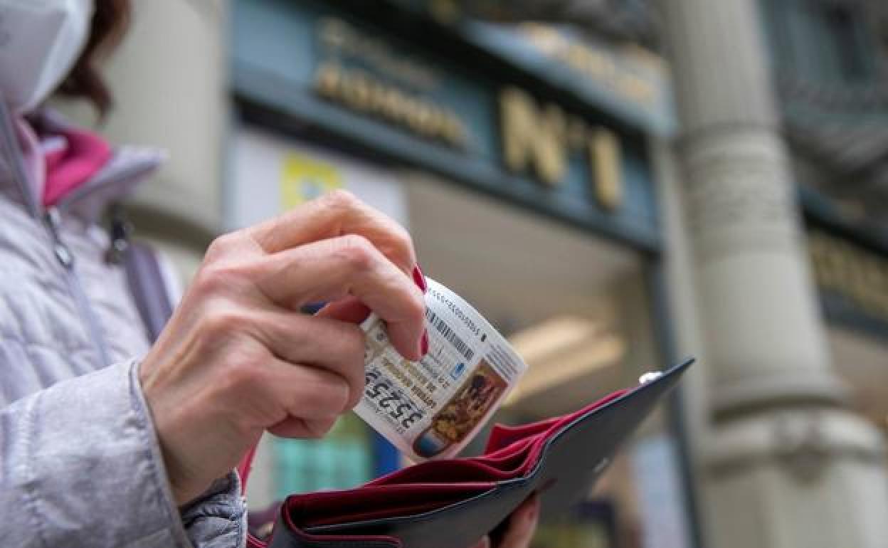 Una mujer guarda su décimo.