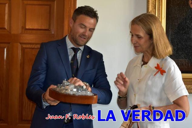 La Infanta Elena fue recibida por el alcalde de Caravaca, José Francisco García, en el Ayuntamiento; saludó a los concejales de la Corporación Municipal y firmó en el libro de honor del consistorio. El regidor caravaqueño entregó a doña Elena una maqueta del castillo-basílica de la Vera Cruz bañada en plata y varios pares de alpargatas de yute fabricadas en una fábrica caravaqueña. La misma que también ha servido este producto artesanal a la Reina Letizia y a Doña Sofía.