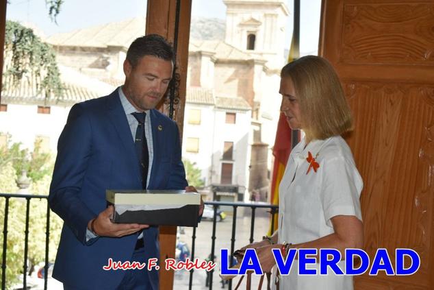 La Infanta Elena fue recibida por el alcalde de Caravaca, José Francisco García, en el Ayuntamiento; saludó a los concejales de la Corporación Municipal y firmó en el libro de honor del consistorio. El regidor caravaqueño entregó a doña Elena una maqueta del castillo-basílica de la Vera Cruz bañada en plata y varios pares de alpargatas de yute fabricadas en una fábrica caravaqueña. La misma que también ha servido este producto artesanal a la Reina Letizia y a Doña Sofía.