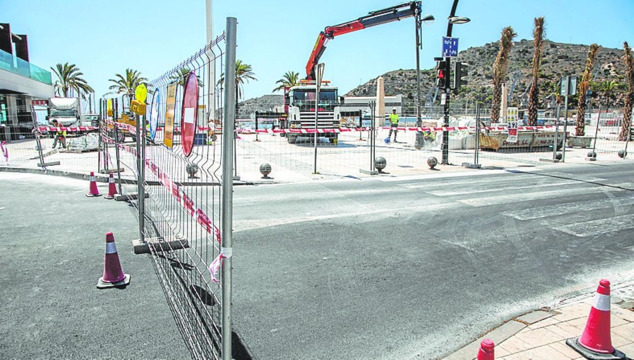 Una grúa descarga material en la explanada del puerto. 