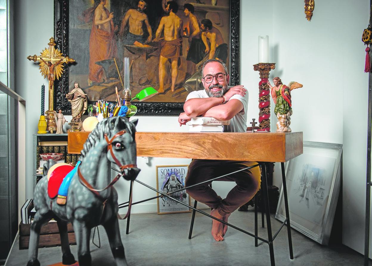 En la imagen, el director del Festival en el despacho de su casa, frente a una copia de 'La Fragua de Vulcano' de Dionisio Callejo, de 1933, académico de San Fernando y copista oficial del Prado, entre libros de historia y arte, antigüedades de los siglos XVII al XIX y escenas del Belén, sus grandes pasiones.