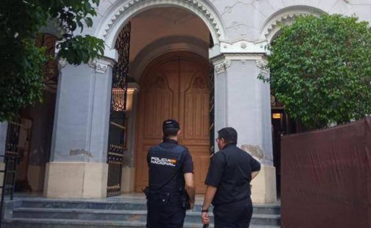 Un agente de la Policía junto al párroco en la puerta de la iglesia de San Bartolomé, en una imagen dea archivo.