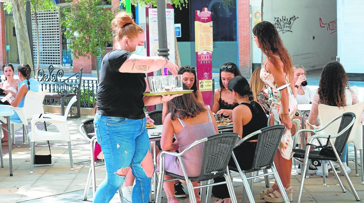 Una camarera atiende a un grupo de clientas en una terraza del centro de Lorca. 