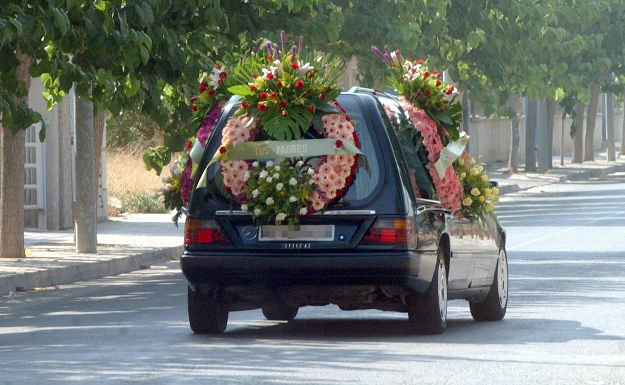 Imagen de archivo de un coche fúnebre transportando un féretro al cementerio.