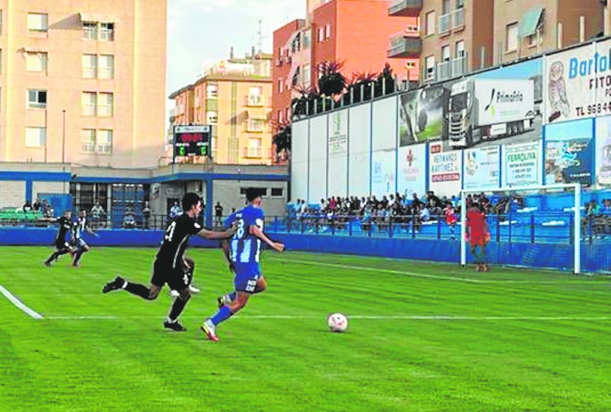 El aguileño Blas corre tras el balón, acosado por un jugador del Bullense, ayer. 