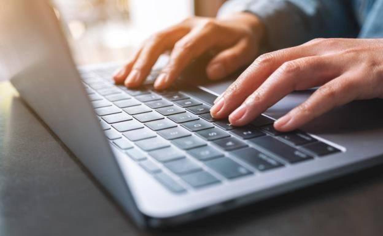 Una persona utiliza su ordenador portátil.