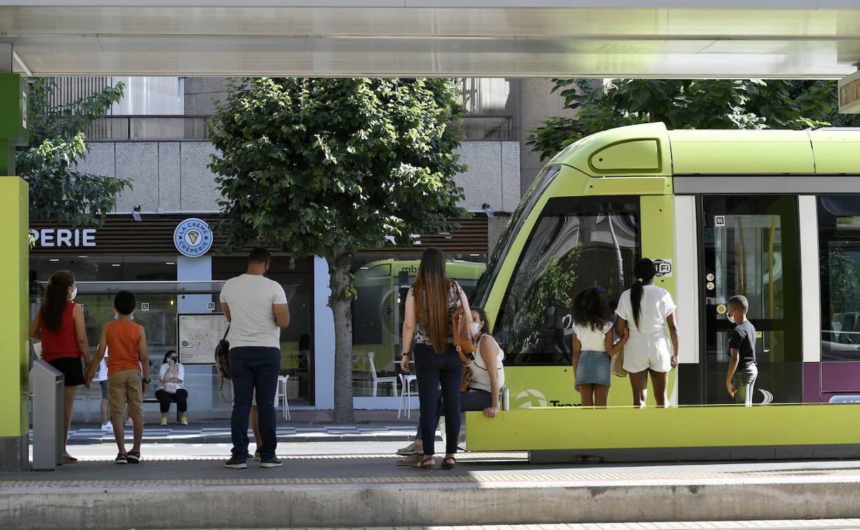 Varios pasajeros esperan la llegada del tranvía, en Murcia.