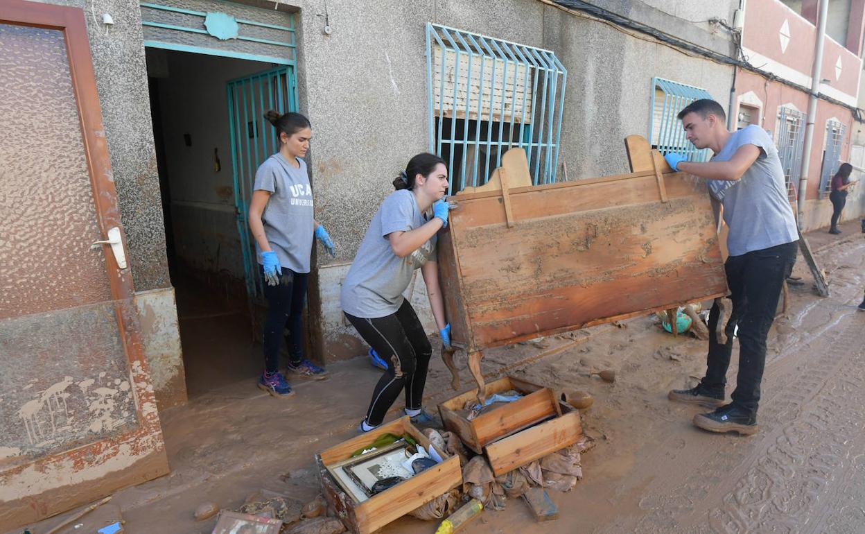 Dos vecinos de Javalí Viejo retiran lodo y enseres de sus viviendas. 