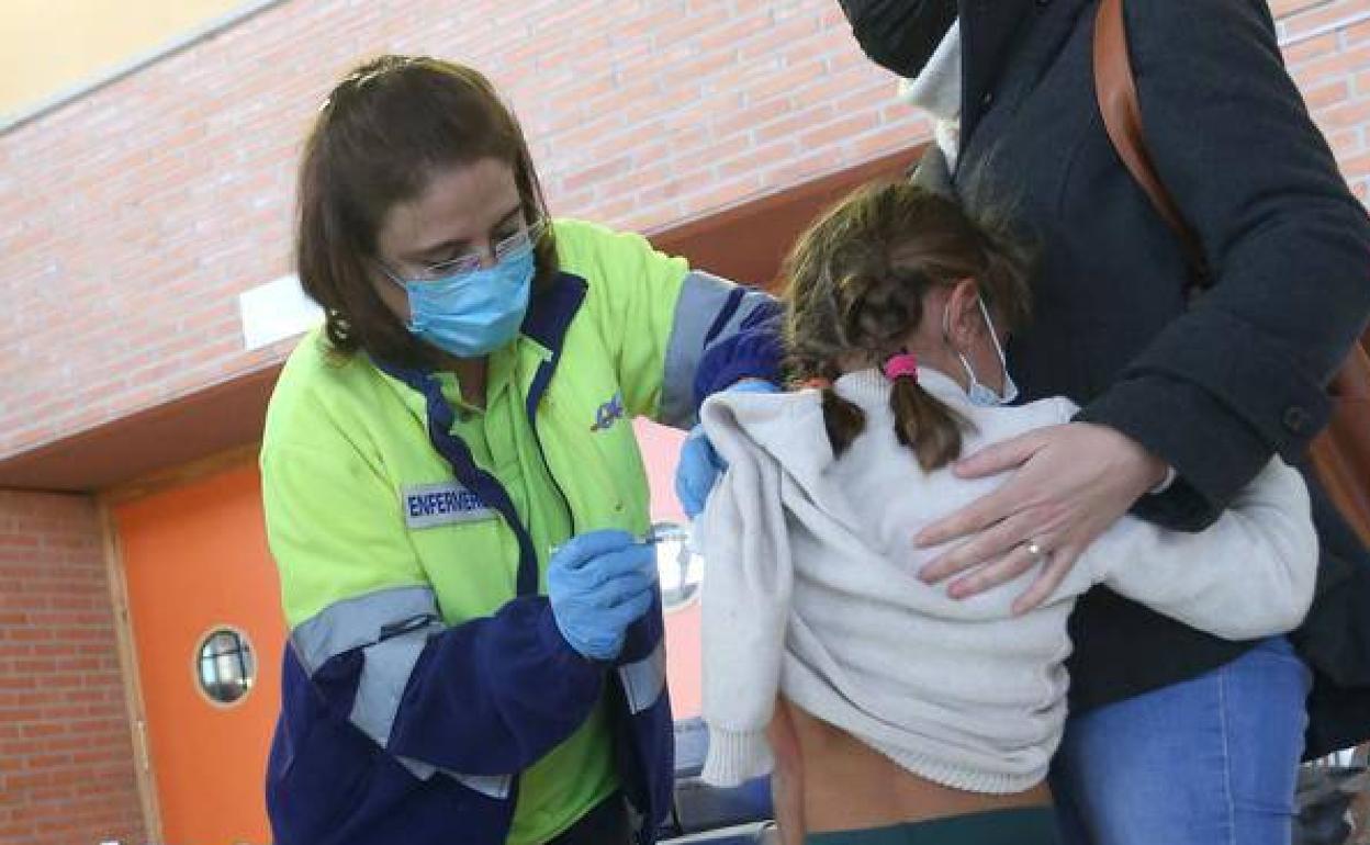 Imagen de archivo de una sanitaria vacunando a una niña. 