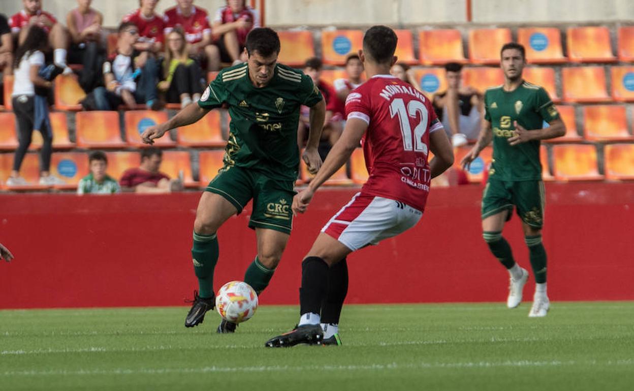 Un jugador del Real Murcia busca avanzar en el terreno de juego.