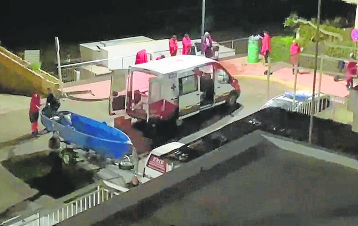 La barca, en primer plano, y sus ocupantes, con mantas, al fondo. 