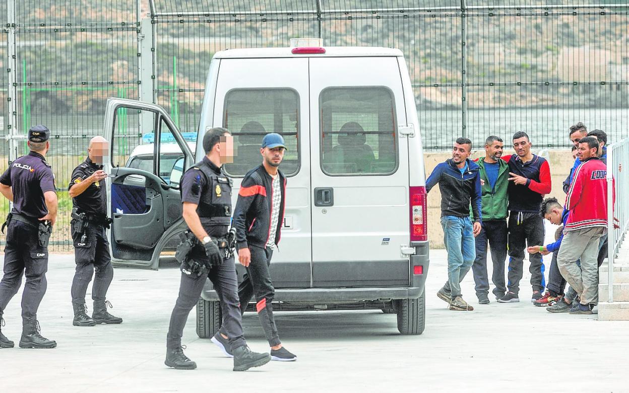 Agentes de la Policía Nacional, custodiando este martes a inmigrantes en el CATE, en El Espalmador. 