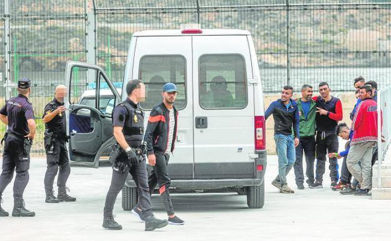 Agentes de la Policía Nacional, custodiando ayer a inmigrantes en el CATE, en El Espalmador. 
