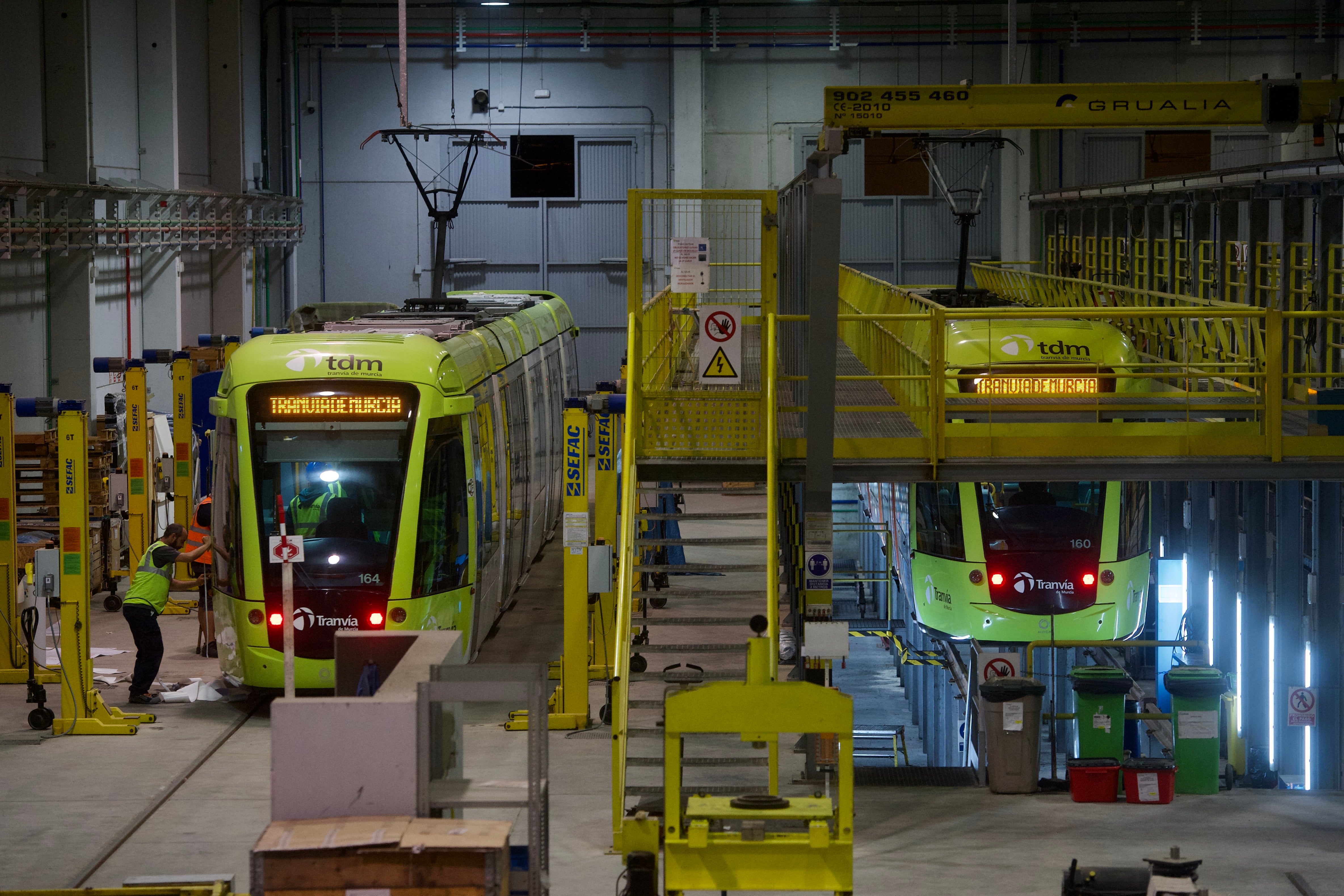 Operarios de Tranvía de Murcia revisan dos vehículos en las instalaciones de La Ladera, uno de ellos, en el foso.