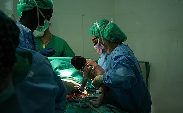 La ginecóloga voluntaria Conchi Carrascosa extrae un bebé tras una cesárea de urgencia. 