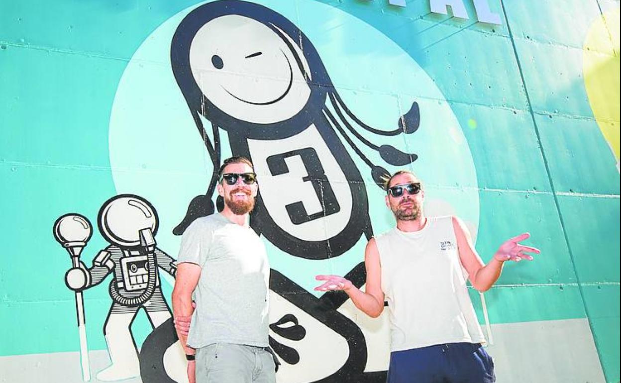 El dúo The London Police posa con su obra a las espaldas.