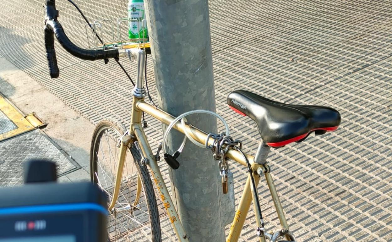 Bicicleta inmovilizada con el bote de cerveza en el manillar. 