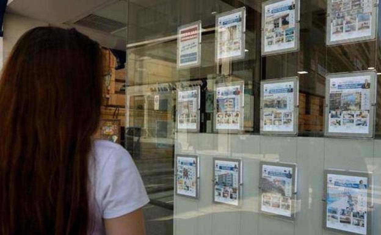 Una mujer observa oferta de pisos en una inmobiliaria, en una imagen de archivo.