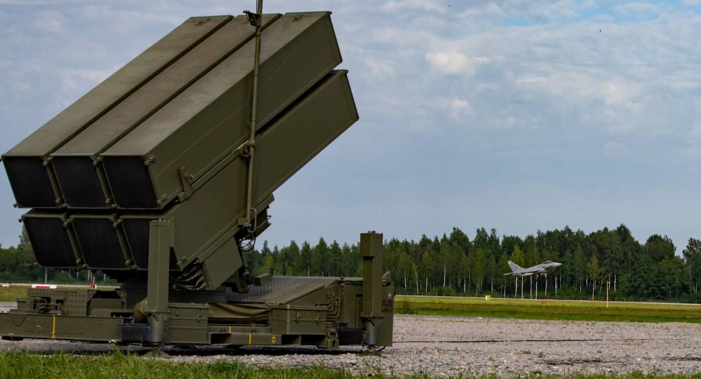 Dos cazas Eurofighter pasan ante un lanzador Nasams.
