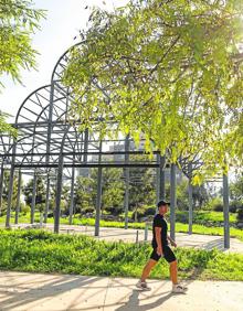 Imagen secundaria 2 - Arriba: cartel del PlanE, que una década más tarde sigue en pie en la Avenida de Murcia. Izquierda: rejillas de la fuente ornamental sin uso del Parque de Los Juncos.. Derecha: un peatón que transita hacia Tentegorra pasa junto a la estructura del quiosco que lleva varios años en el jardín Antonete Gálvez.