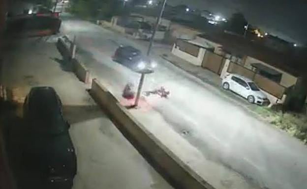 El coche embiste al motorista, que cae y se golpea contra una farola. 