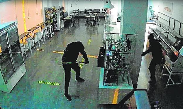 Dos encapuchados fuerzan una caja de autopago en una confitería. 