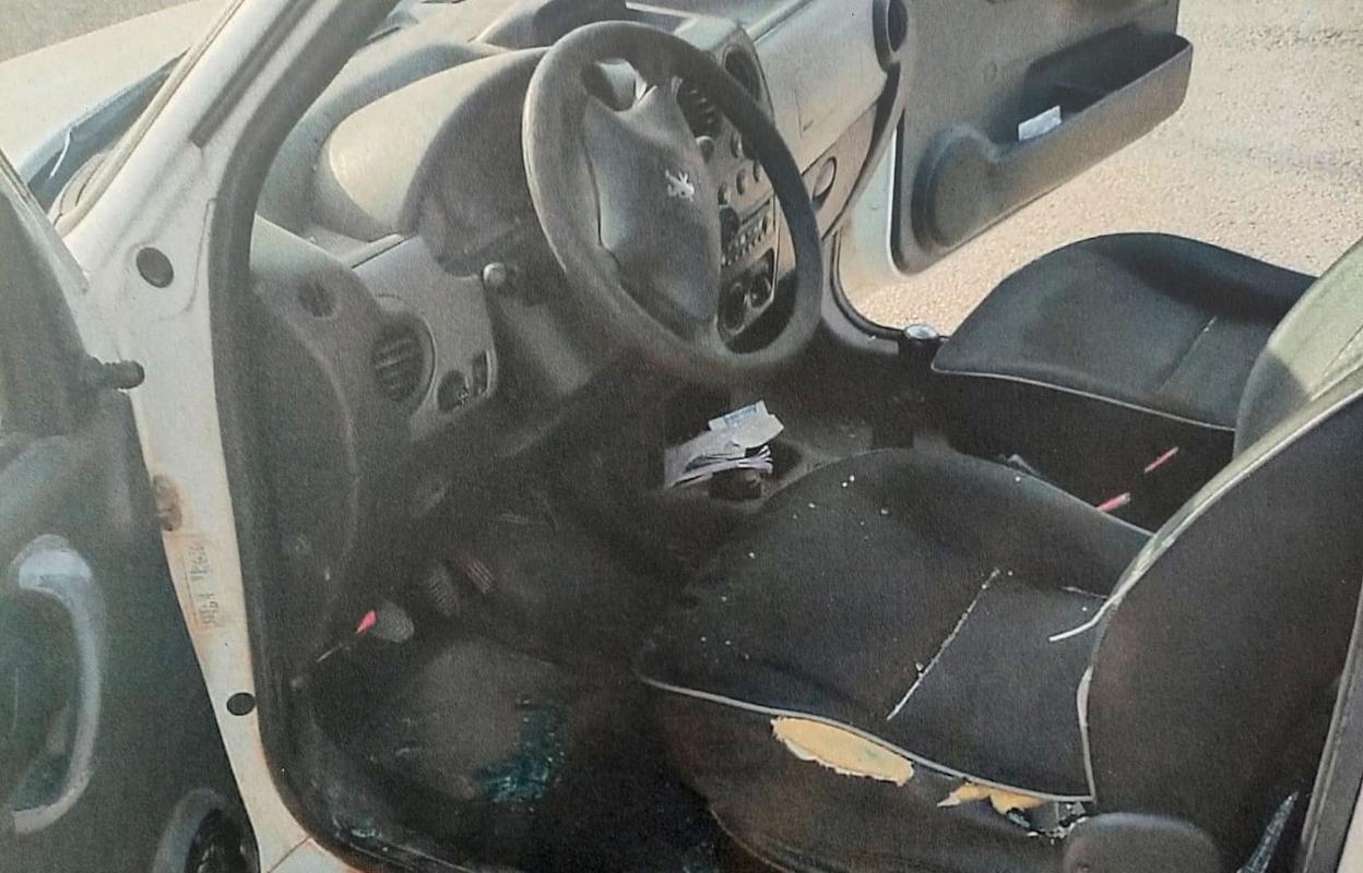 Interior de uno de los vehículos con una ventanilla fracturada. 