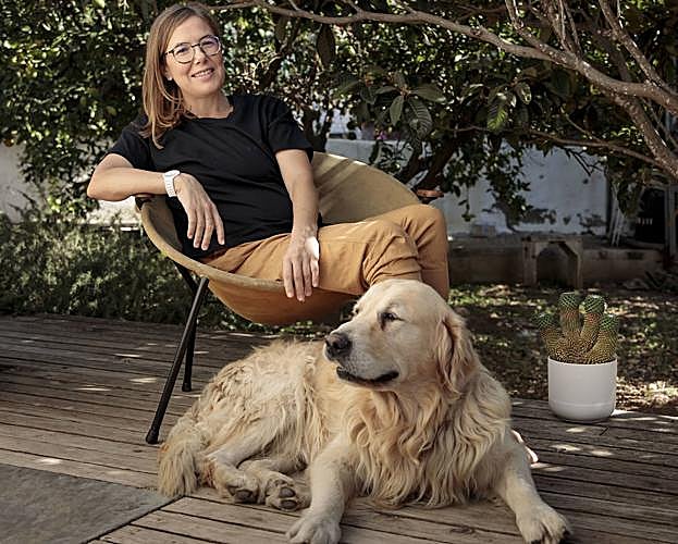 Inma Bermúdez en el jardín de su casa junto a su perro.