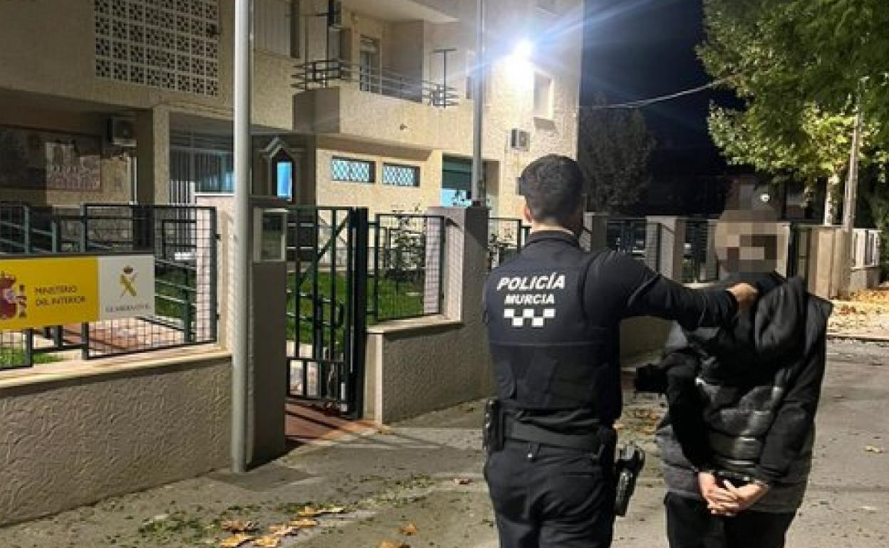 Un agente de la Policía Local junto a uno de los detenidos.