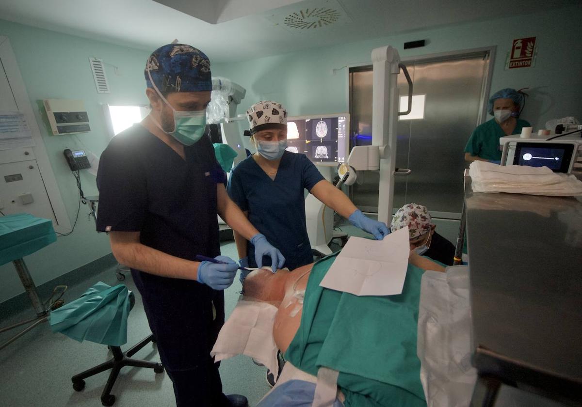 Los neurocirujanos Javier Ros de San Pedro y Beatriz Cuartero se preparan para intervenir a un paciente en La Arrixaca.