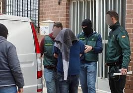 Guardias civiles escoltan a uno de los detenidos durante los registros en la pedanía pachequera de Roldán, este martes.