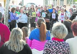 Los vecinos de Pozo Estrecho escuchan a la presidenta vecinal, Susana García, mientras habla por el megáfono.